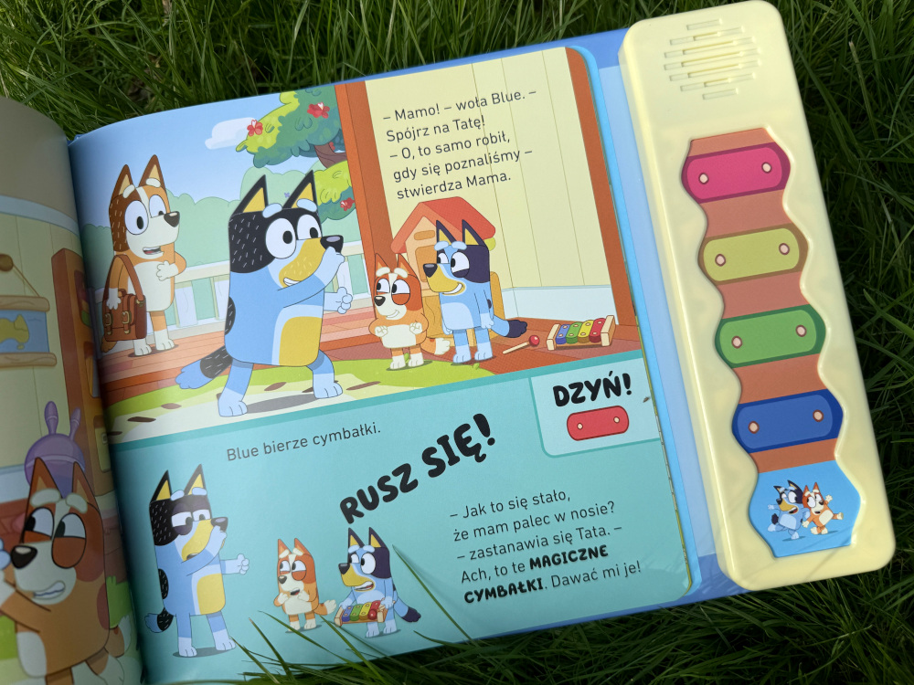 Bluey Magiczne cymbałki – wprowadzenie do muzycznego świata książek dla dzieci
Szukasz idealnej książki z dźwiękami dla najmłodszych dzieci na wakacje? „Bluey Magiczne cymbałki” to kolorowa i pełna radości propozycja dla wszystkich małych czytelników, a także wielbicieli sympatycznego Bluey! Jeśli Twoje dziecko jeszcze nie zna tej uroczej bohaterki bajki – najwyższy czas to zmienić!
Książeczka dźwiękowa z Bluey – zabawa, nauka i muzyka
Magiczne cymbałki nie są zwykłą książką – dzięki panelowi dźwiękowemu to także interaktywna zabawka! Odkrywanie kolejnych historii z Bluey i jego bliskimi to czysta frajda, zwłaszcza kiedy można bawić się kolorami i dźwiękami cymbałków. Czytelnicy pomagają Bluey i siostrze Bingo zaczarować – i odczarować – tatę. Dotykając odpowiednich przycisków, mali odkrywcy wywołają dziecięcy beztroski śmiech.
Książka o dzieleniu się i codziennych emocjach – przesłanie Bluey dla maluchów
Przygody Bluey pełne są dziecięcej codzienności. Pomiędzy gilgotkami i zabawą pojawiają się ważne życiowe lekcje: „Czekanie na swoją kolej bywa trudne”, ale przecież zabawa jest najfajniejsza wtedy, kiedy potrafimy się dzielić z innymi. W słowach mamy Bluey znajdziesz mądre przesłanie:
„… Dziel się z innymi, jeśli chcesz, żeby inni dzielili się z tobą – uczy Mama.”
Dlaczego warto wybrać Bluey Magiczne cymbałki? – recenzja książki z dźwiękami
„Bluey Magiczne cymbałki” została wydana z dużą starannością, idealnie trafiając w potrzeby najmłodszych czytelników. Kolorowa, wyrazista, pełna pozytywnych emocji – to nie tylko świetna zabawa, ale też nauka podejmowania decyzji, samodzielności i kreatywności. Dzieci mogą samodzielnie uruchamiać dźwięki, wpływając na przebieg zabawy. Jestem pewna, że ta książeczka zagości w Waszych domach na dłużej – „będziecie czytać tę przygodę bez końca”.
Panel dźwiękowy z tyłu działa na baterie i można go włączyć lub wyłączyć w dowolnym momencie – Ty decydujesz, kiedy magia dźwięków towarzyszy lekturze!
Bluey Magiczne cymbałki – książka z przesłaniem i muzyką [podsumowanie]
Książeczka dźwiękowa dla najmłodszych czytelników.
Interaktywna zabawa z kolorami i dźwiękami.
Wartościowe przesłanie o dzieleniu się i cierpliwości.
Rozwój samodzielności, kreatywności oraz motoryki małej.
Wspaniała lektura na rodzinne, wakacyjne czytanki.