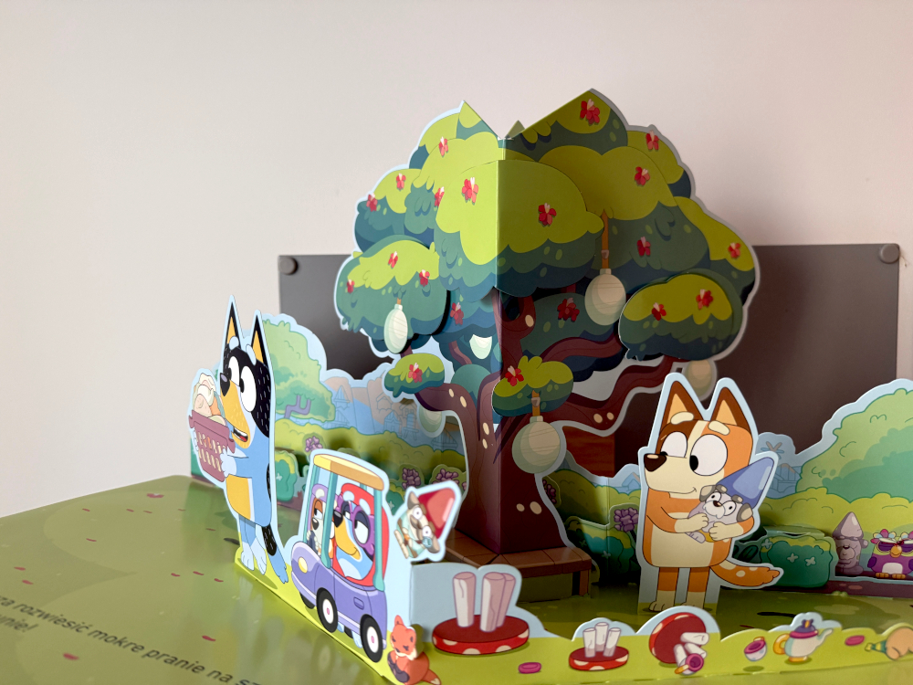 Trójwymiarowe wnętrze książki Bluey Wielki Pop Up z ogrodem rodziny Łączków