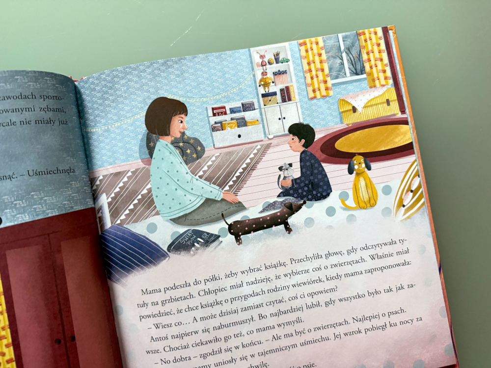 Mama czyta synowi książkę na dobranoc – ilustracja z książki Fuksik Piesek z parkingu, ciepła scena rodzinnej bliskości.