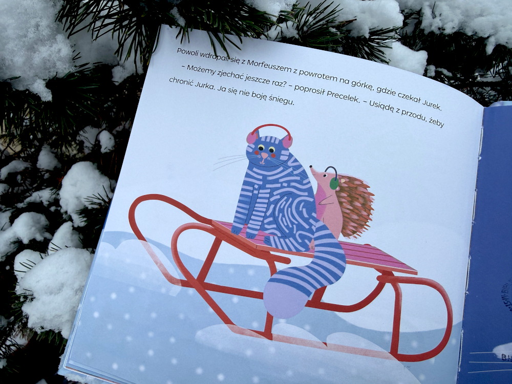 Kot Precelek i język Jurek siedzą na sankach