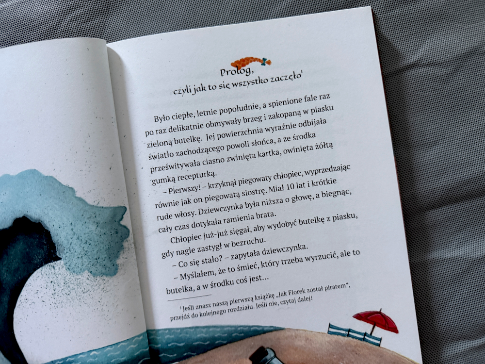 Otwarta książka dla dzieci Marzenia Mili prezentująca tekst prologu oraz ilustrację morskiej fali i plażowego parasola.