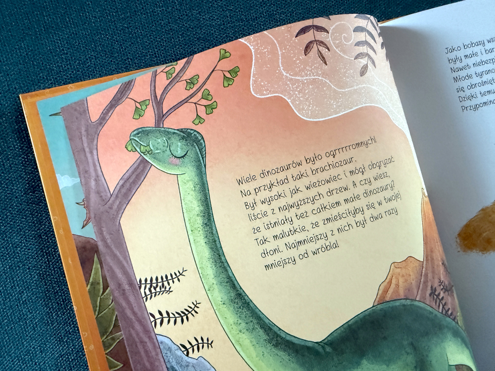 Bogato ilustrowana strona z książki o dinozaurach dla dzieci przedstawiająca brachiozaura sięgającego do koron drzew.