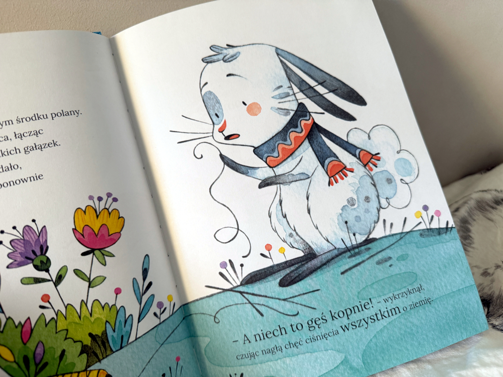 Ilustracja z książki Możesz na nas liczyć – zajączek w szaliku na jesiennym pagórku wśród kwiatów.