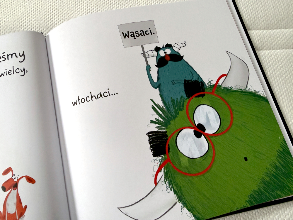 Ilustracja z książki Potwory też mają uczucia – zielony potwór w czerwonych okularach z hasłem „Wąsaci”.