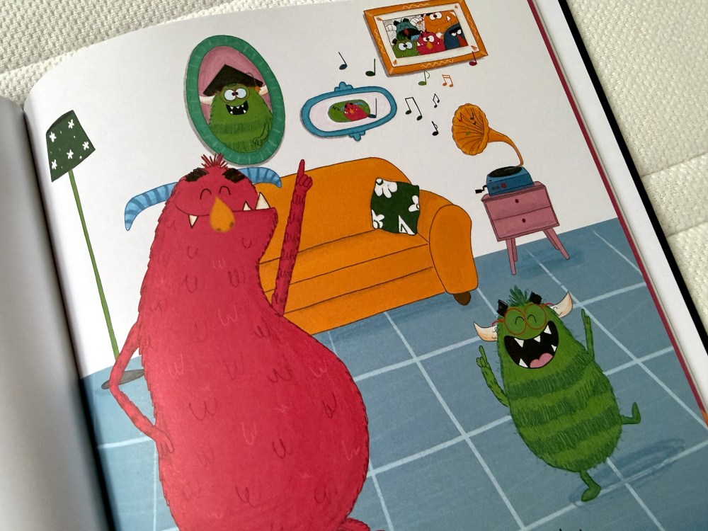 Rozkładówka książki o emocjach dla dzieci – kolorowe potwory z transparentami o uczuciach.