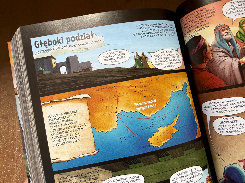 Otwarta rozkładówka Biblia komiks z mapą podróży Pawła, sceną podziału i dialogami w komiksowych dymkach.