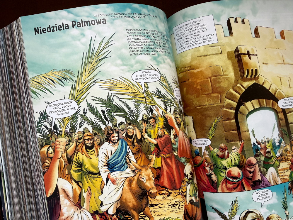 Otwarta rozkładówka Biblia komiks z Niedzielą Palmową, palmami i sceną wjazdu Jezusa do Jerozolimy.