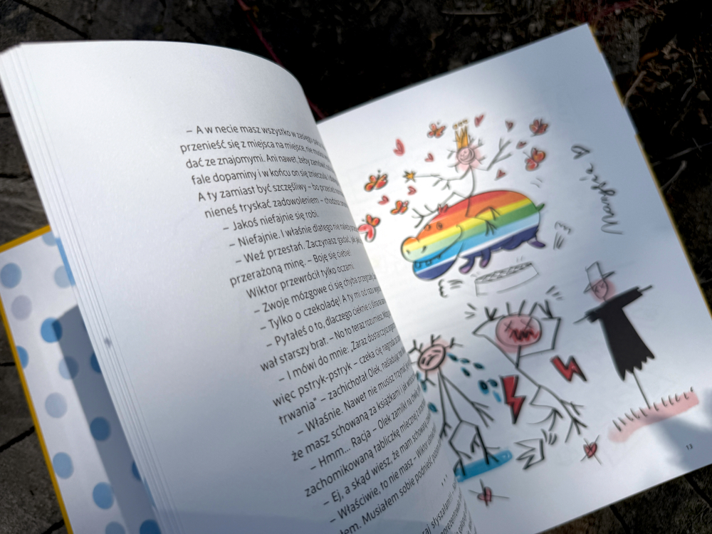 Rozkładówka książki Alborytmy Hipotama z kolorową ilustracją, dziecięcymi rysunkami i wątkiem emocji oraz dopaminy