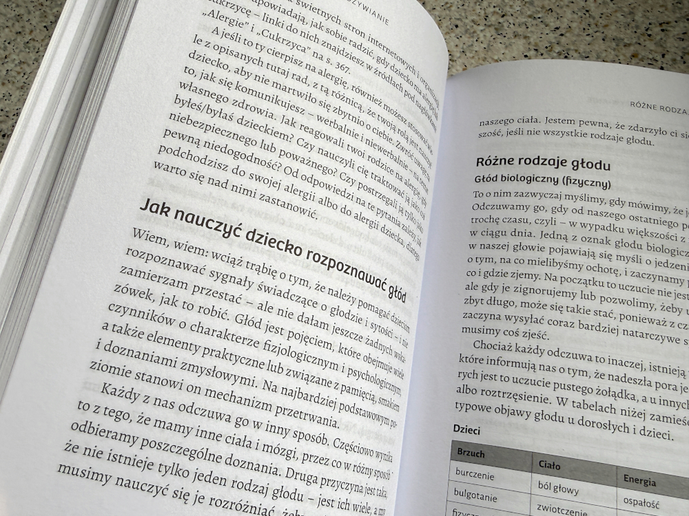 Rozkładówka książki Jak rozmawiać z dziećmi o jedzeniu z rozdziałem o rozpoznawaniu głodu i tabelą objawów sytości