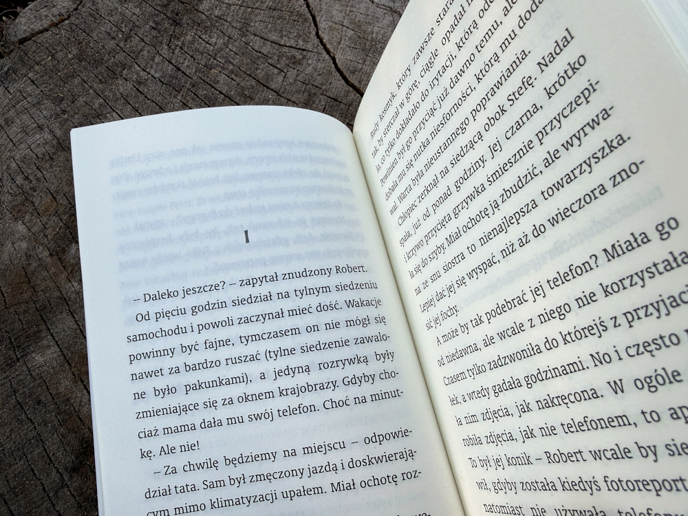 Wnętrze książki dla dzieci z dialogiem bohaterów widoczne na dwóch stronach podczas czytania powieści przygodowej