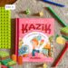 Okładka książki Kazik i obowiązki domowe z ilustracją chłopca podczas codziennych domowych aktywności