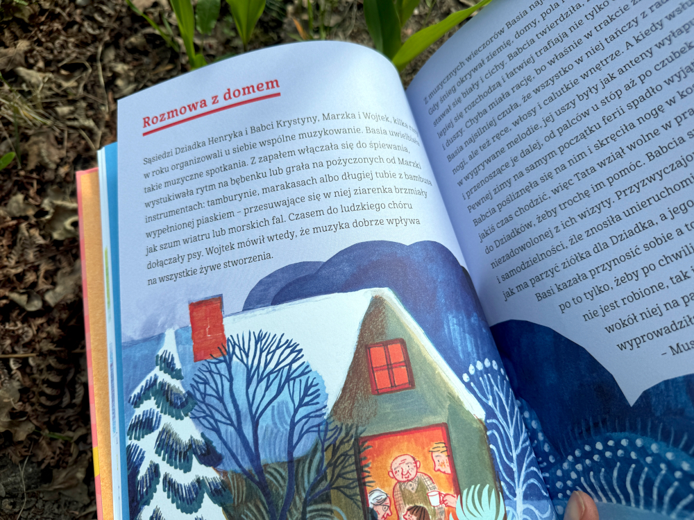 Otwarte strony książki Basia Wielka księga zmysłów z zimową ilustracją domu i rozdziałem o słuchu