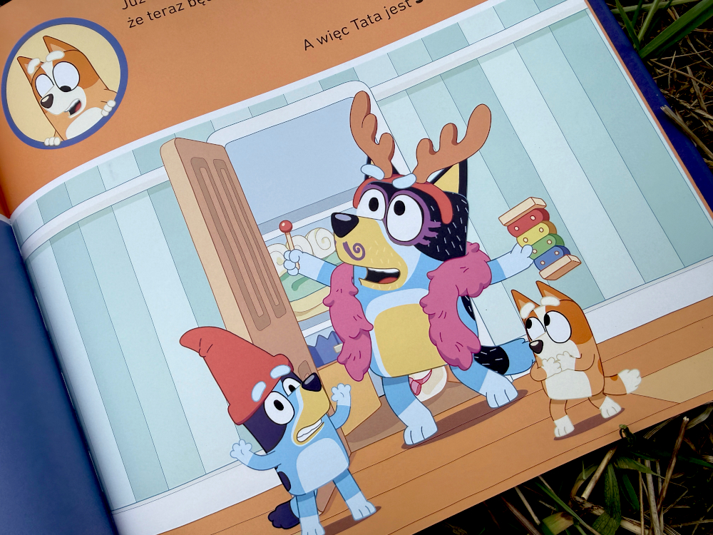 Bluey książki o mamie i tacie - tata przebrany w rogi jelenia bawi się z Blue i Bingo