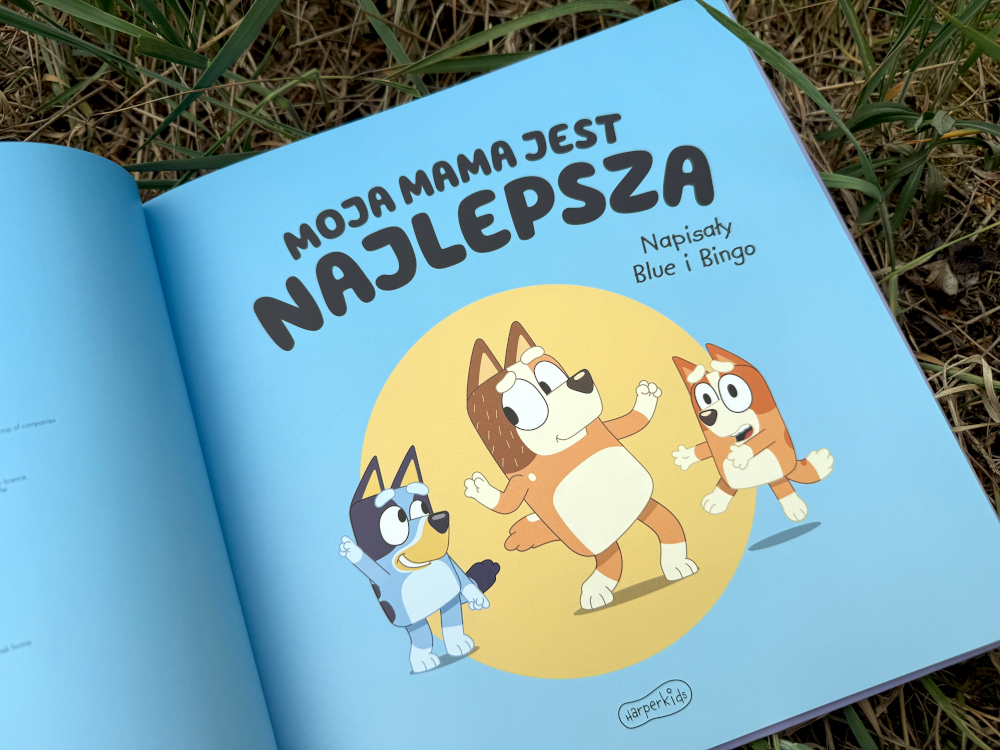 otwarta książka dla dzieci Bluey Moja mama jest najlepsza na trawie, ilustracja mamy z Blue i Bingo na niebieskim tle