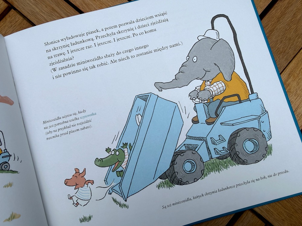 Strona książki edukacyjnej z miniwozidłem prowadzonym przez słonia i zwierzętami na placu zabaw