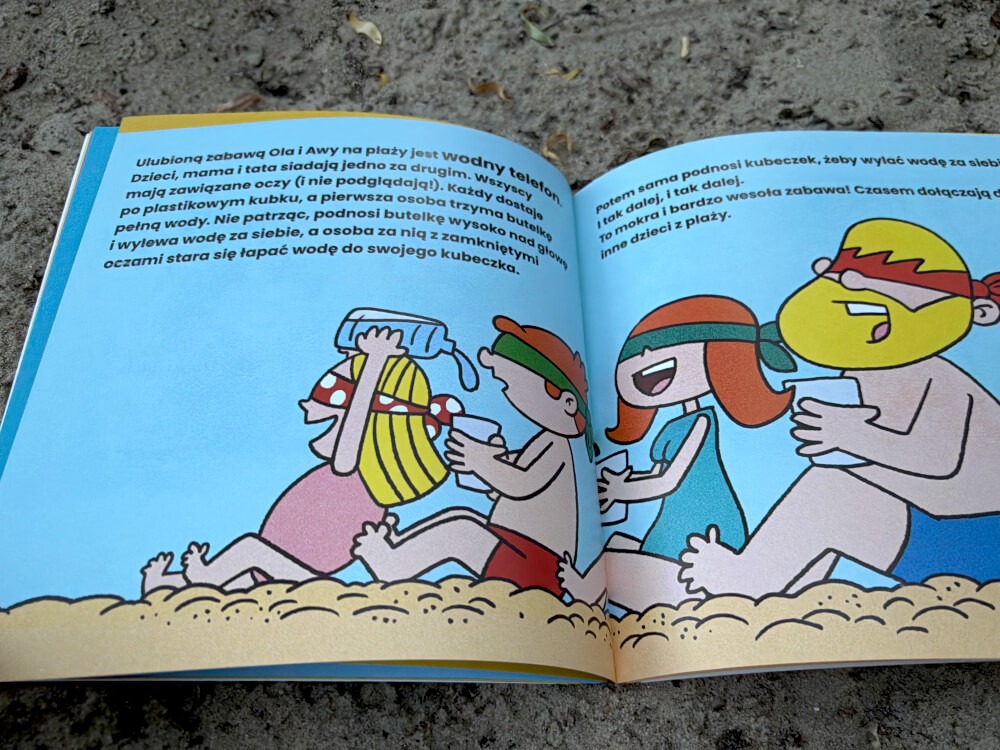 Zabawa "Wodny telefon" na plaży, rodzina siedzi w rzędzie i przelewa wodę z kubka na kubek nad głową. (