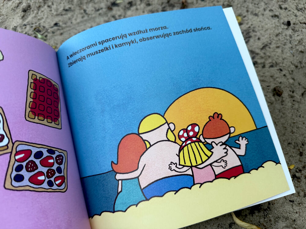 Rodzina przytula się na plaży i ogląda zachód słońca nad morzem, na sąsiedniej stronie są gofry z owocami.