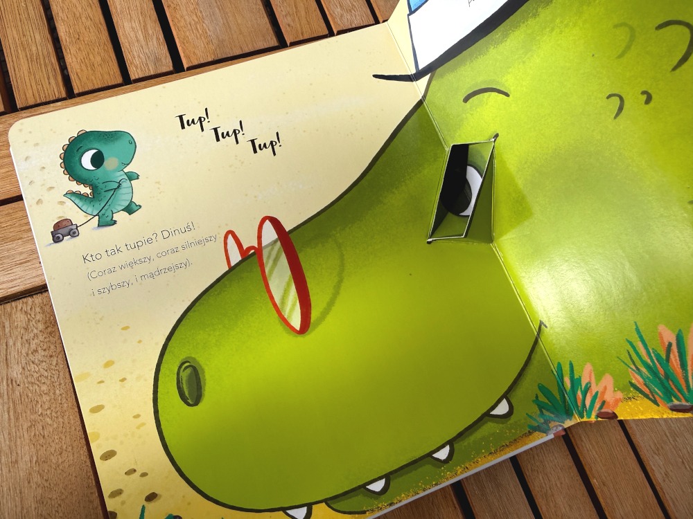 Trójwymiarowy element z ruchomymi okularami w książce Dinuś chce być duży o rosnącym dinozaurze.
