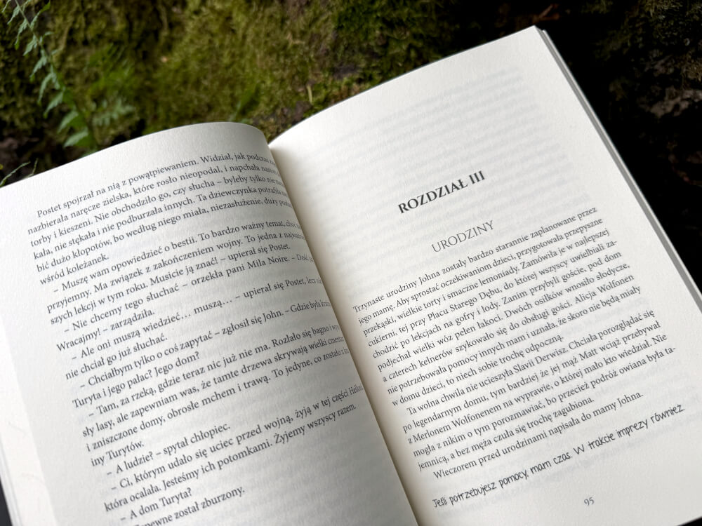Rozkładówka powieści fantasy Hellonia z dialogiem bohaterów i nagłówkiem Rozdział III Urodziny