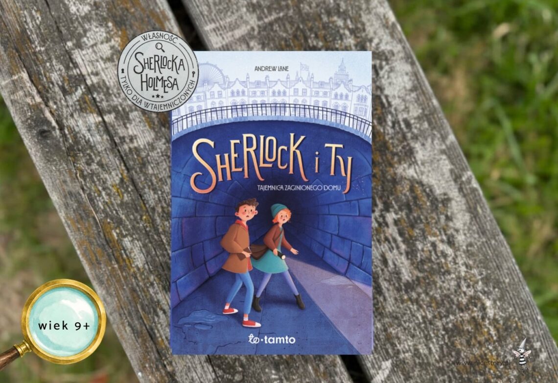 ￼Niebieska okładka książki Sherlock i Ty. Tajemnica zaginionego domu z ilustracją dwójki dzieci w tunelu na tle Londynu, leżąca na drewnianej ławce. W rogu znaczek wiek 9+