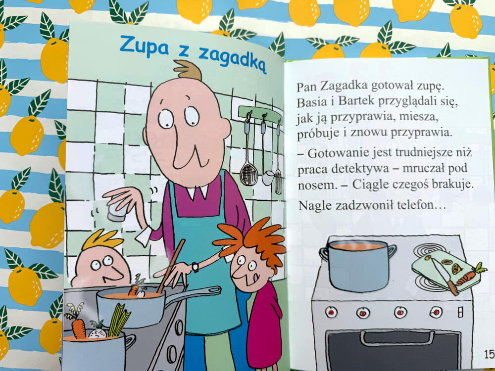 Rozłożona książka. Lewa strona pokazuje detektywa w fartuchu, gotującego z dziećmi przy kuchence. Prawa strona to ciąg dalszy tekstu rozdziału Zupa z zagadką.